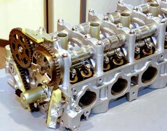 В головке блока двигателя с системой VTEC-i знакомый механизм VTEC (хорошо видны три кулачка на два клапана) соседствует с устройством поворота впускного распредвала, встроенным в звездочку цепного привода